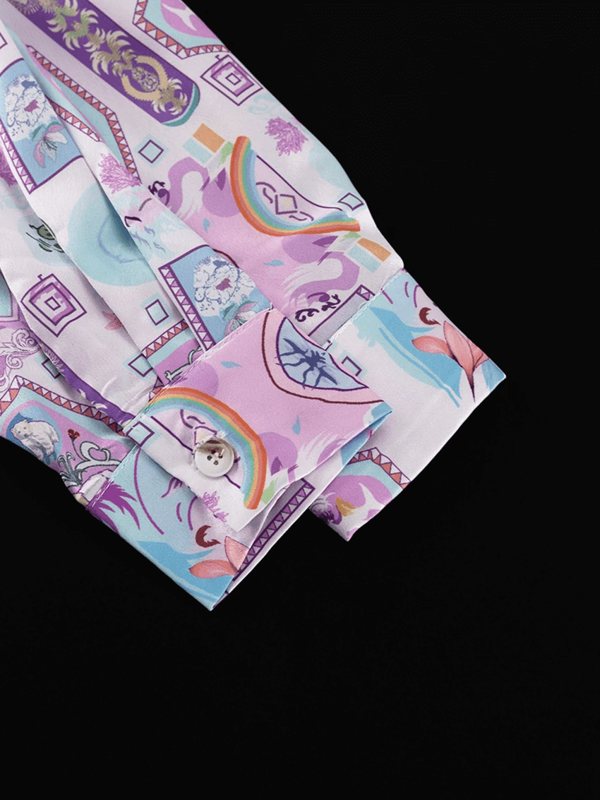 Polsino della camicia in satin con fantasia arcobaleno e motivi decorativi vintage, chiuso da bottone bianco.
